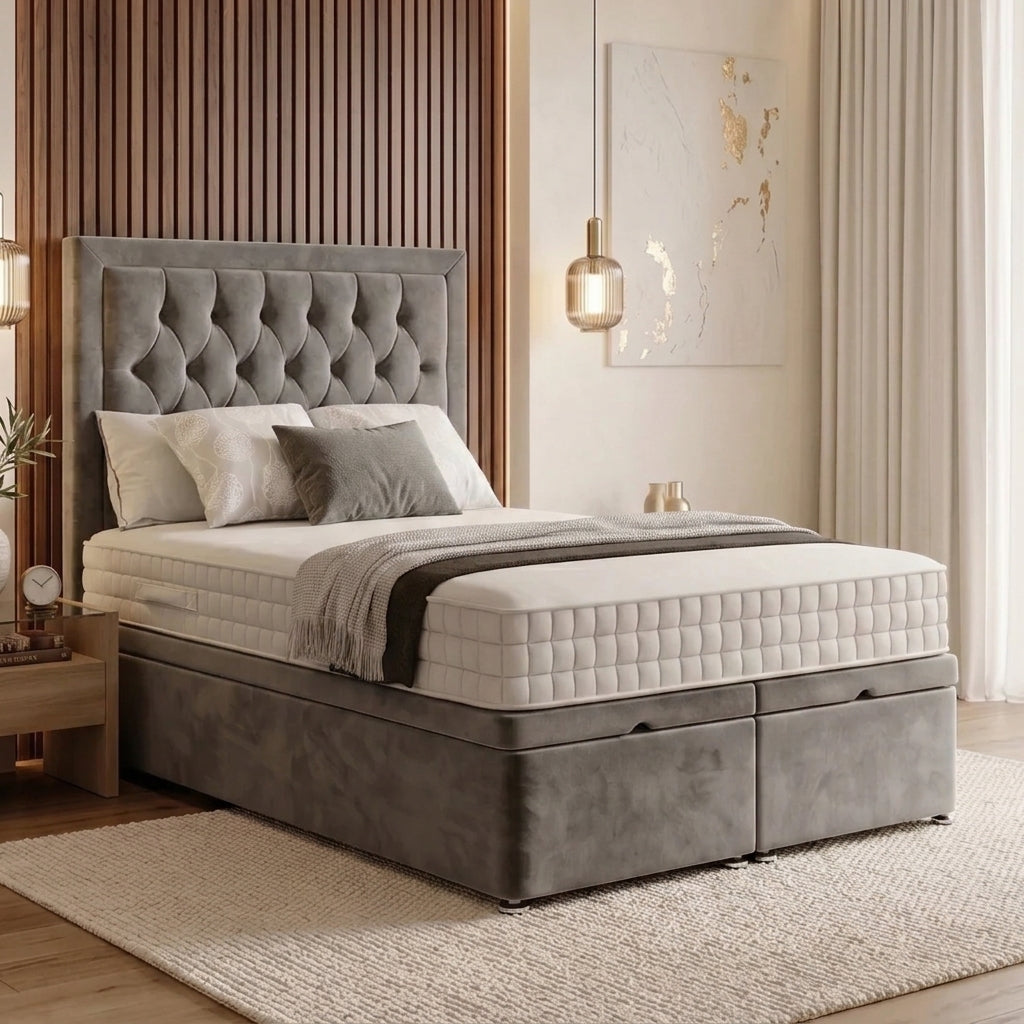 A modern gray upholstered bed with a tall tufted headboard and storage base, shown in a styled bedroom setting with white bedding, a wooden slat wall, and a hanging lamp.