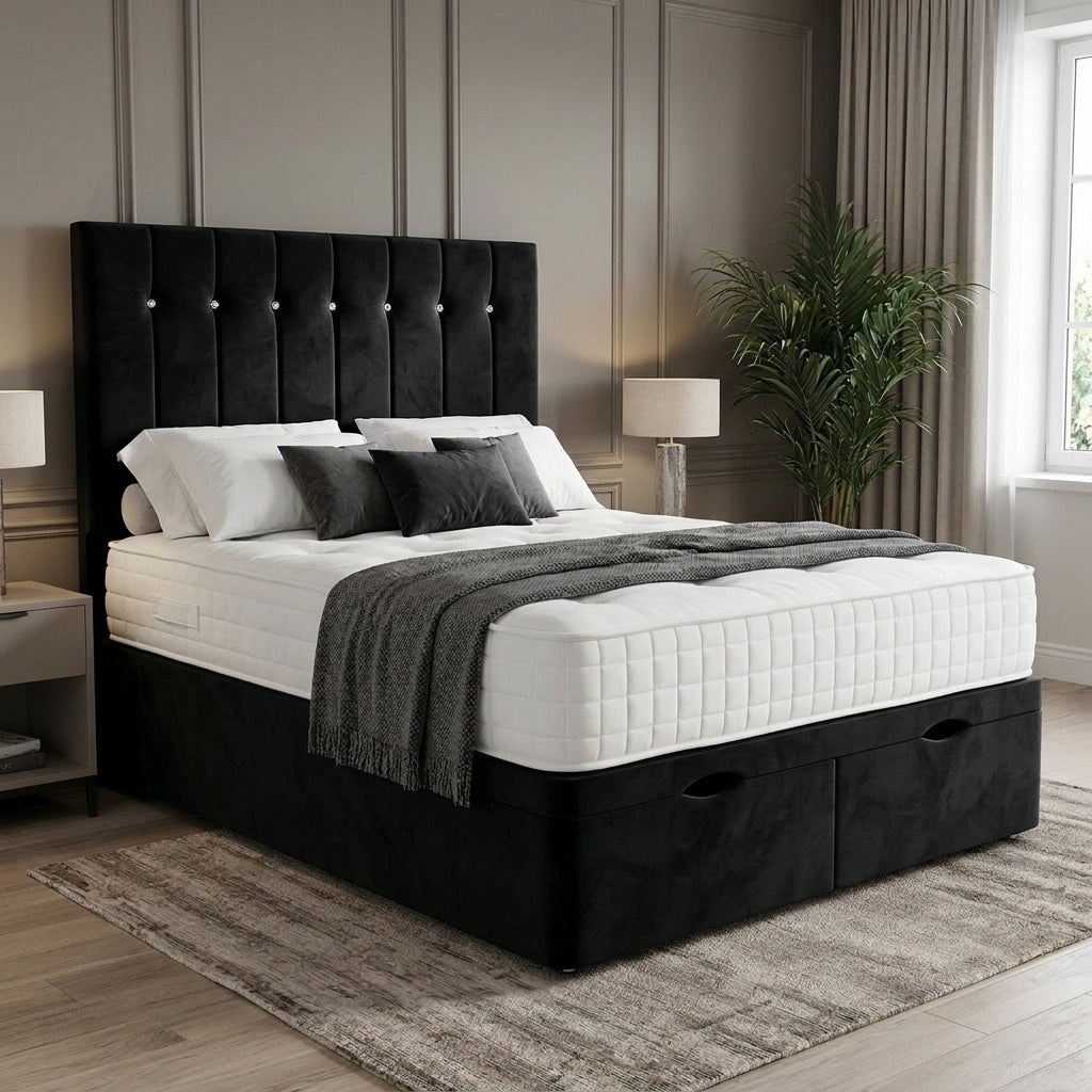 A black upholstered bed with a tall tufted headboard and storage base, dressed in white bedding and a gray throw, shown in a styled bedroom setting.